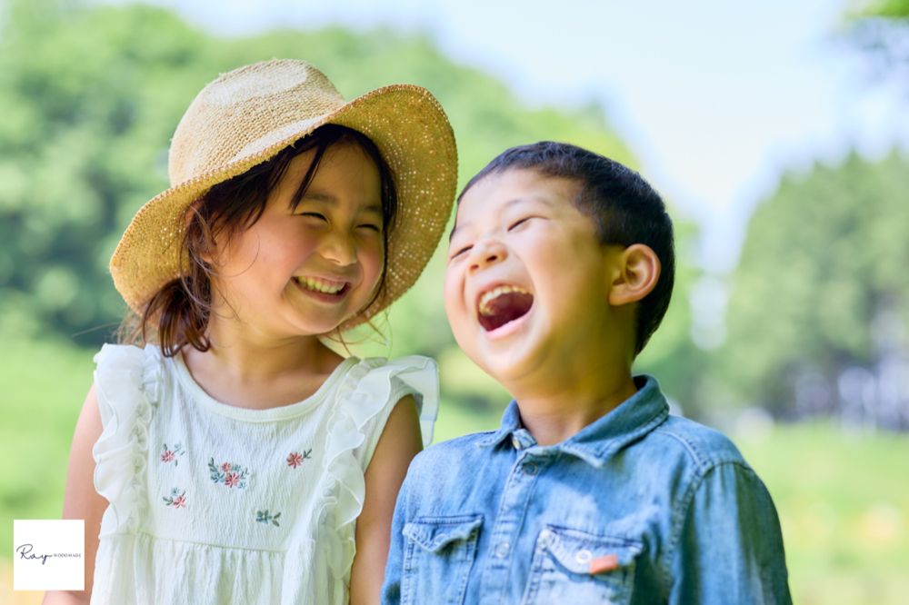 夏の屋外で大笑いする子どもたちのイメージ