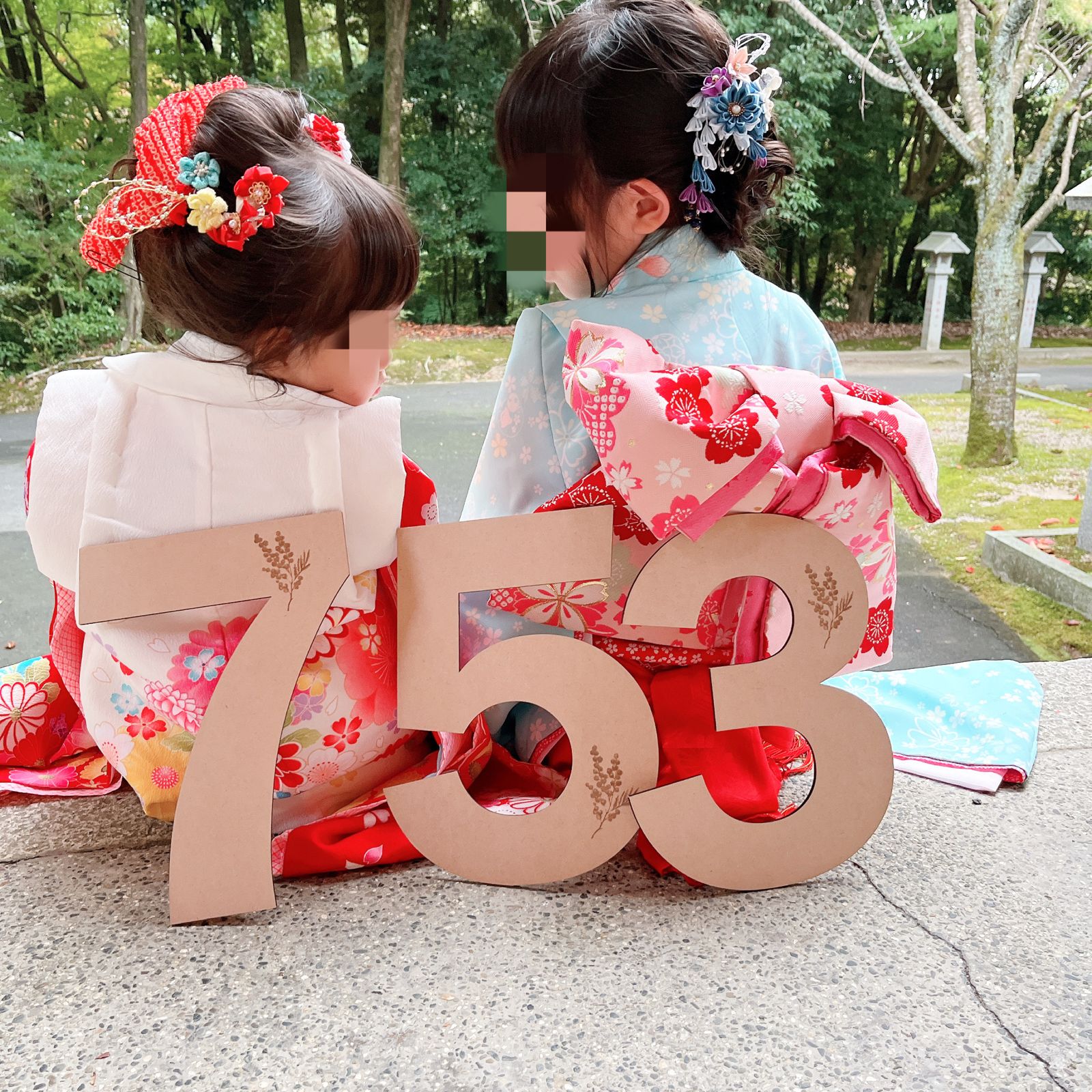 七五三の木製753ナンバーを持って座る姉妹